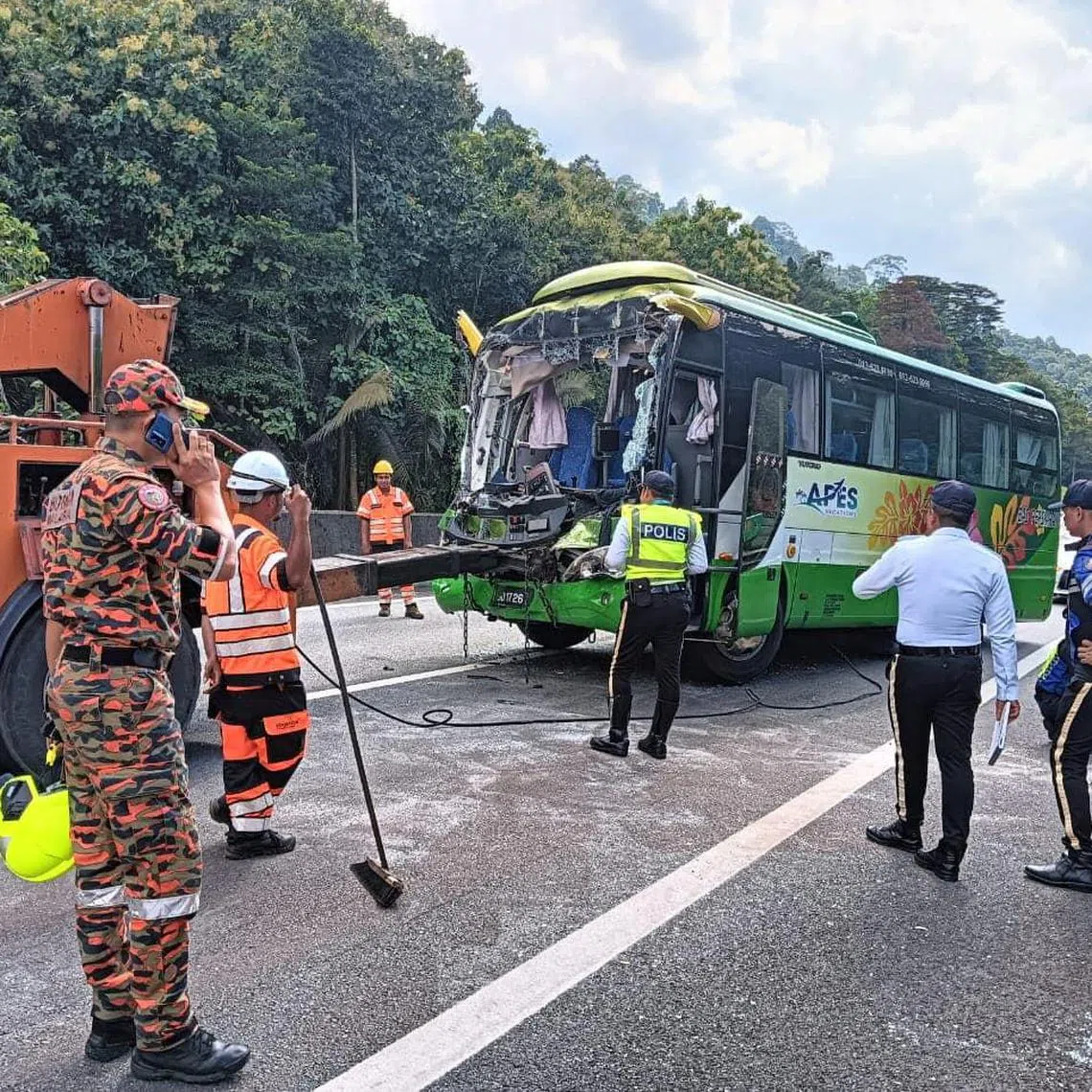 A firefighter and police stand at the site of a fatal road accident involving a bus, in Taiping, Perak, Malaysia, October 24, 2024. Perak Fire and Rescue Department (JBPM Perak)/Handout via REUTERS    THIS IMAGE HAS BEEN SUPPLIED BY A THIRD PARTY MANDATORY CREDIT. NO RESALES. NO ARCHIVES