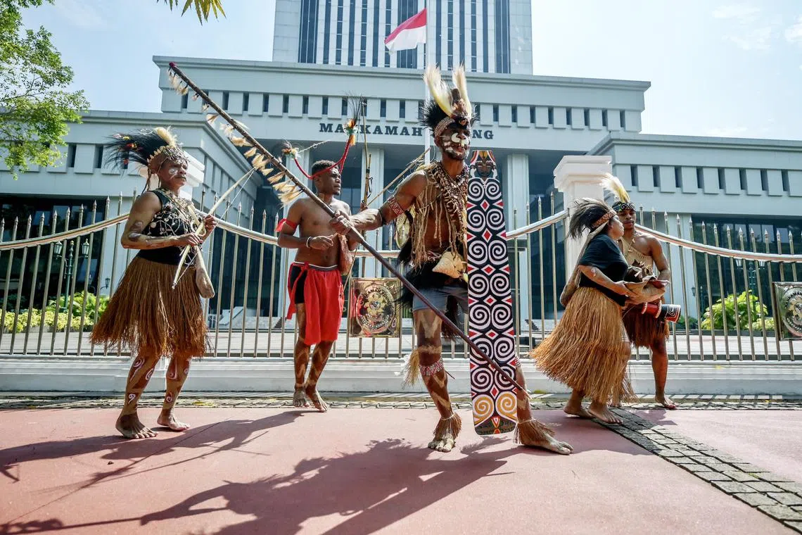 Representatives of the Awyu and Moi indigenous tribes dance and perform rituals in front of the Supreme Court building in Jakarta on May 27, 2024, during a protest, together with environmental activists, as they called on the Supreme Court to revoke the permits of palm oil companies that are set to operate on Papuan land.