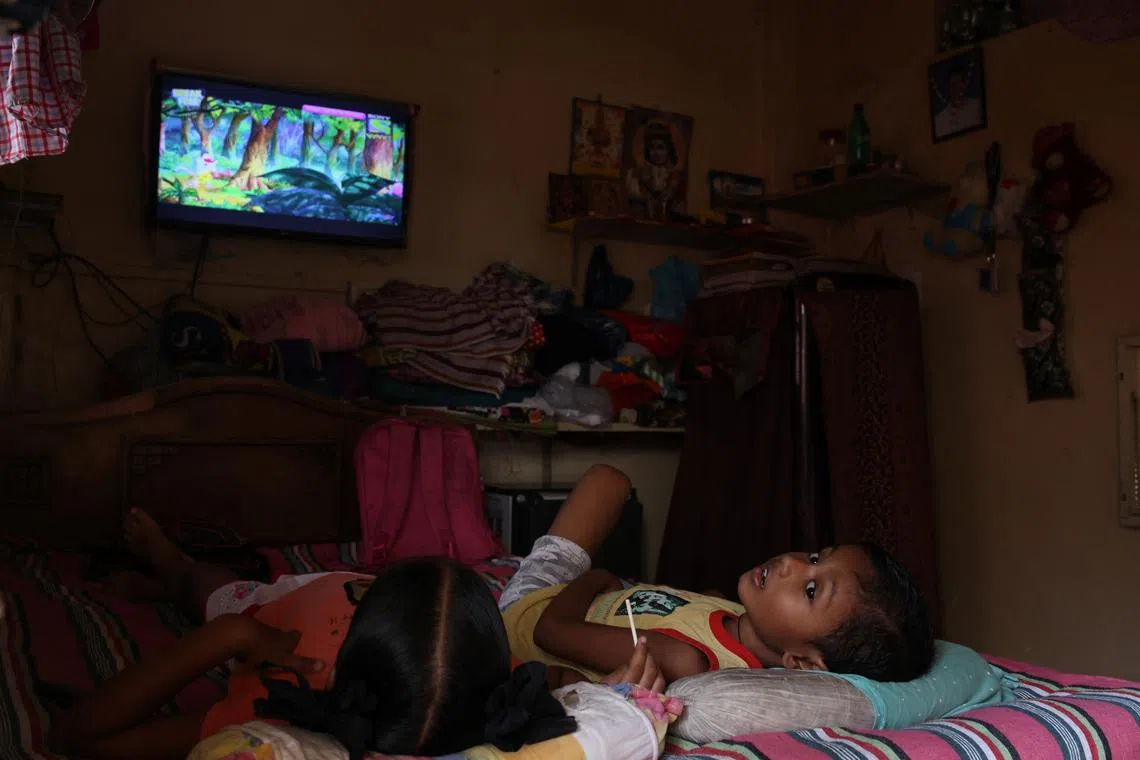Sheikh Moulana Mehmood's grandchildren watching television inside the Worli Dairy quarters building in Mumbai, India, Oct 5, 2022. "Living here is risky, especially with children," said Sheikh.  