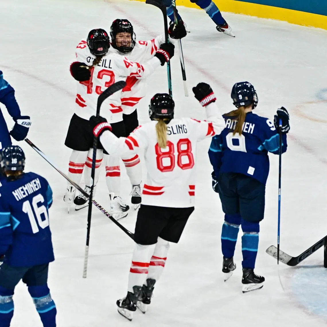 Milano Cortina 2026 Olympics - Ice Hockey - Women's Preliminary Round - Group A - Finland vs Canada - Milano Rho Ice Hockey Arena, Milan, Italy - February 12, 2026. Jennifer Gardiner of Canada celebrates scoring their first goal with Kristin O'Neill of Canada and Julia Gosling of Canada REUTERS/Marton Monus