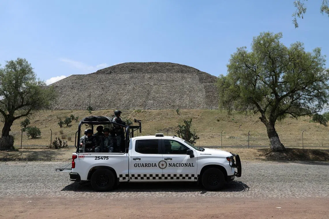 Members of the National Guard stand on a vehicle with the Pyramid of the Moon in the backgroun, at the perimeter of the Teotihuacan pyramids after a gunman killed a Canadian woman and wounded several others before killing himself, authorities said, at one of the country's most visited tourist sites, in San Martin de las Piramides on the outskirts of Mexico City, Mexico, April 21, 2026.