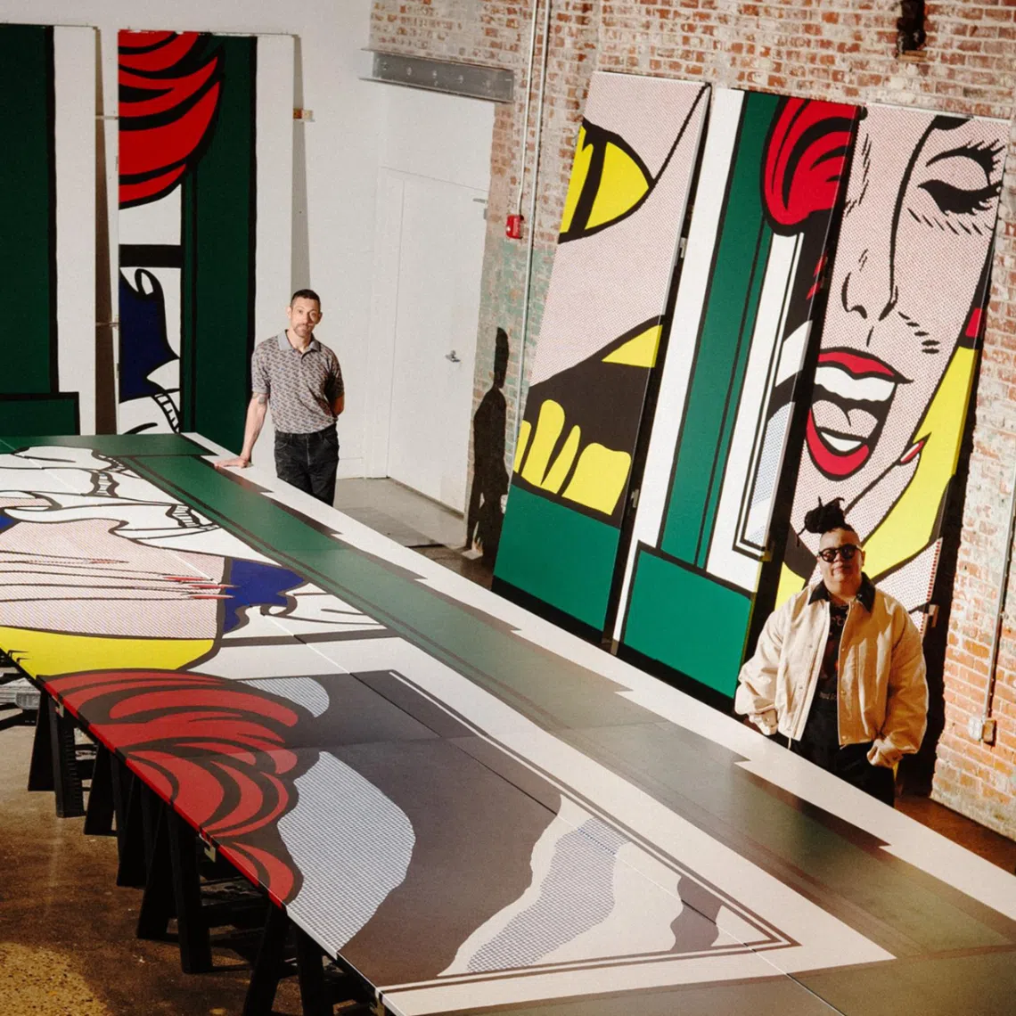 Artist Alex Da Corte, left, with curator Meg Onli, right, who are mounting the Whitney Museum of American Art’s exhibition, “Roy Lichtenstein: Like New,” stand with exhibit panels at a studio on Aug 17, 2026. The show, which opens Oct. 11, will bring together a vast swath of Lichtenstein’s work, whose last New York retrospective was some 33 years ago.