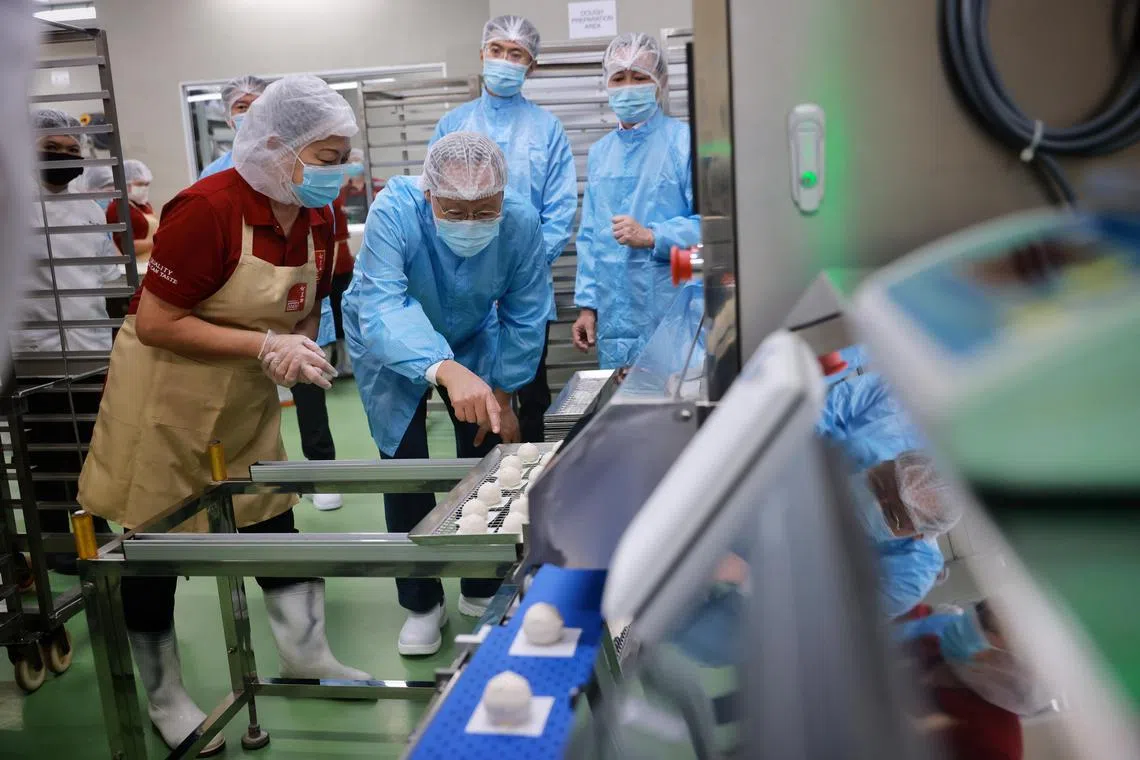 Minister for Manpower Tan See Leng viewing an automated pau machine at Sin Mui Heng Food Industries on Dec 14, 2022.