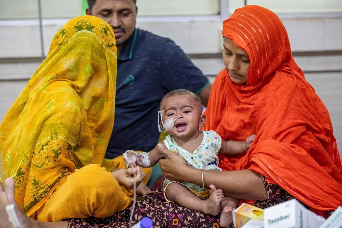 A woman comforts a child diagnosed with measles at the Bangladesh Shishu Hospital and Institute in Dhaka on May 6. Doctors are struggling to contain a surge in infections among children.