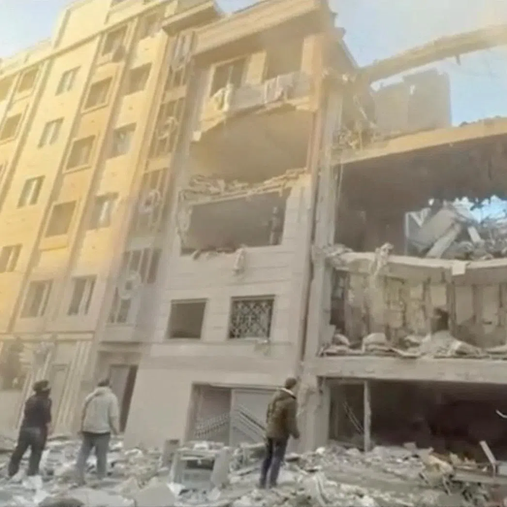 People stand near damaged buildings, amid the U.S.-Israeli conflict with Iran, in Tehran, Iran, in this still image obtained from a handout video released on April 1, 2026.    Iranian Red Crescent Society/Handout via REUTERS