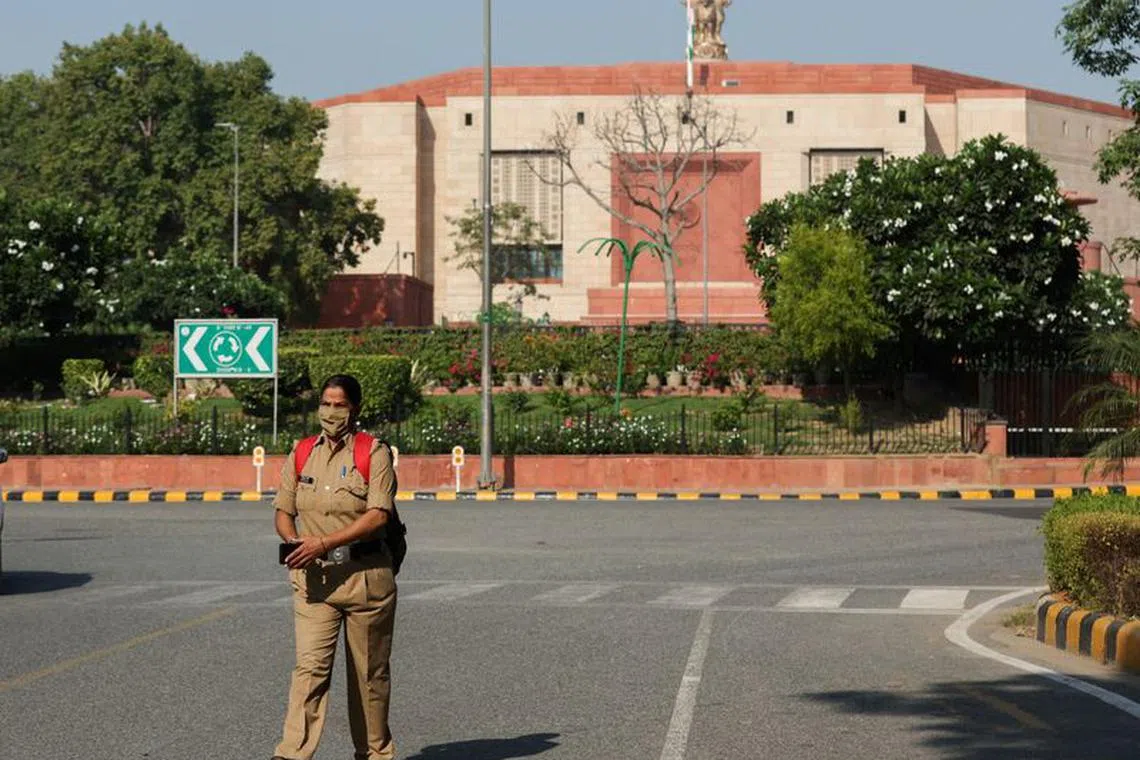 FILE PHOTO: A policewoman walks past a street across India's new parliament in New Delhi, India, September 20, 2023. REUTERS/Anushree Fadnavis/File Photo