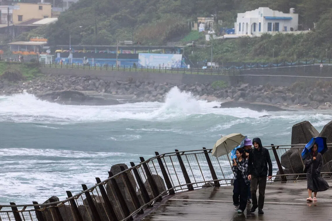 People use umbrellas to shield from the rain and the wind as Typhoon Fung-wong approaches, in Keelung, Taiwan, on Nov 10.