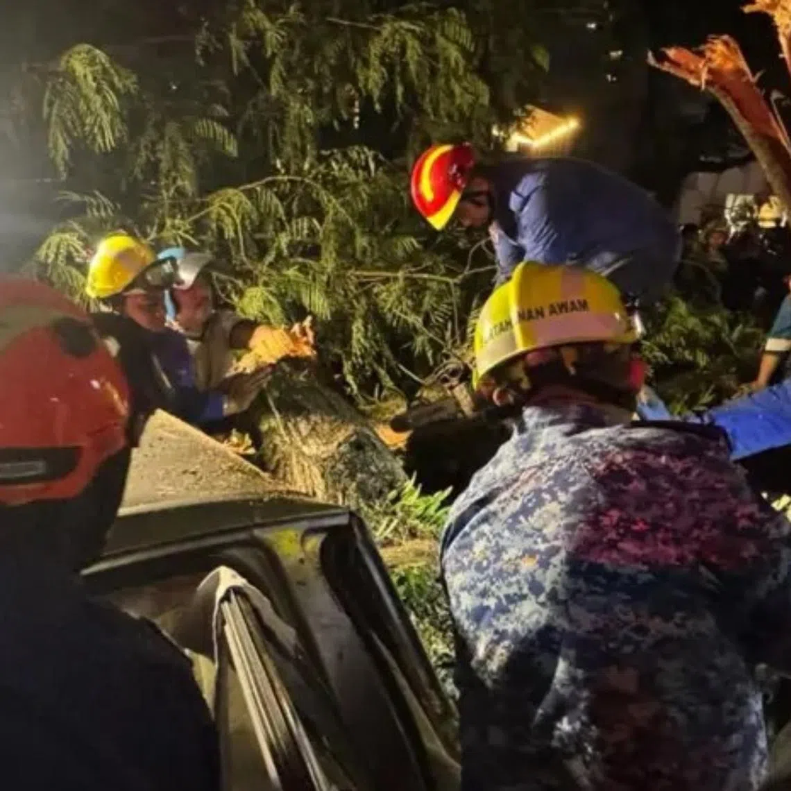 Rescuers clearing tree debris along Jalan Tun Razak in Kuala Lumpur, Malaysia.