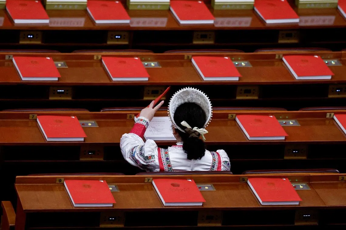 FILE PHOTO: A delegate in an ethnic minority costume arrives before the closing session of the National People's Congress at the Great Hall of the People in Beijing, China March 12, 2026. REUTERS/Tingshu Wang/File Photo