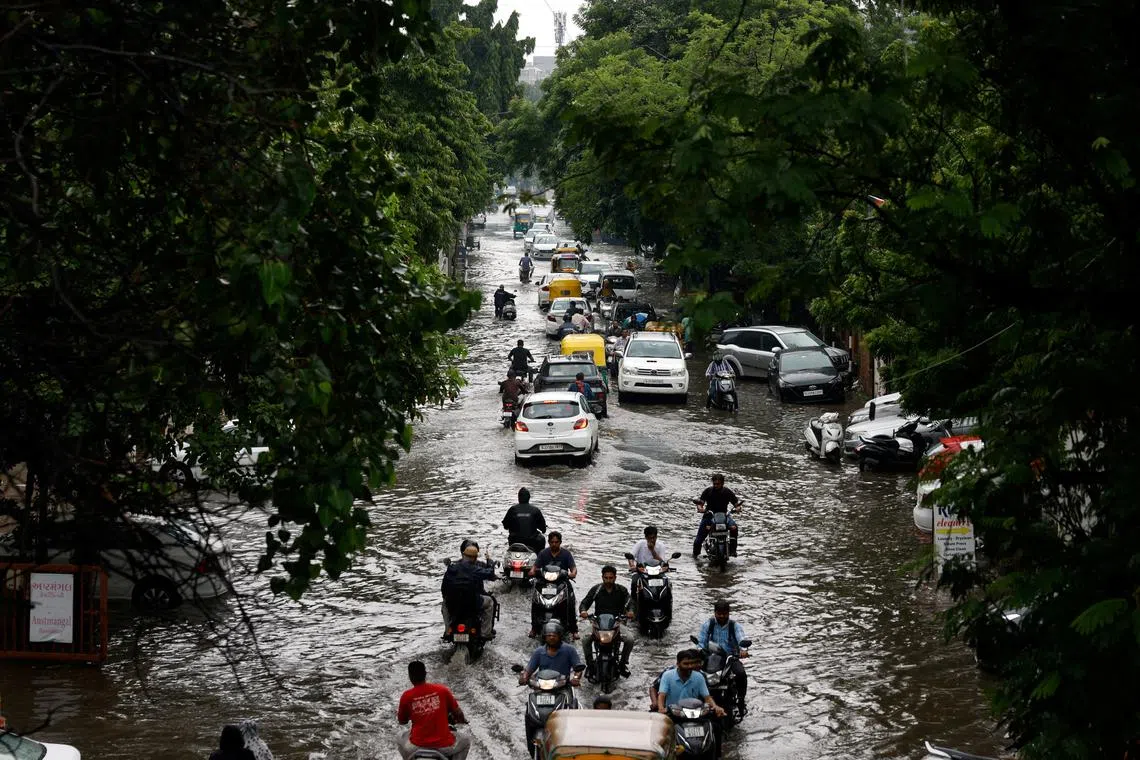 FILE PHOTO: Traffic moves through a flooded road after heavy rains in Ahmedabad, India, August 22, 2024. REUTERS/Amit Dave/File Photo