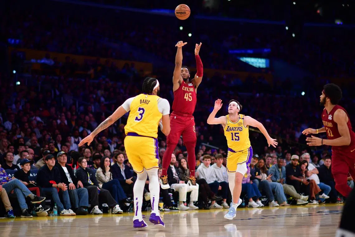 Cleveland Cavaliers guard Donovan Mitchell shoots against Los Angeles Lakers forward Anthony Davis and guard Austin Reaves during the second half at Crypto.com Arena.