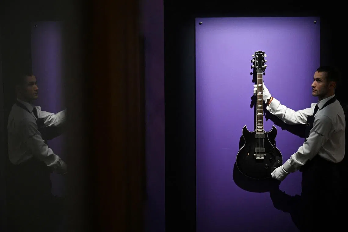 A staff holding a VOX HDC-77 Electric guitar used by the late musician and singer, Prince, during a press photocall at Sotheby's auction house for the Popular Culture Auction, in central London, on Sep 9, 2024. 