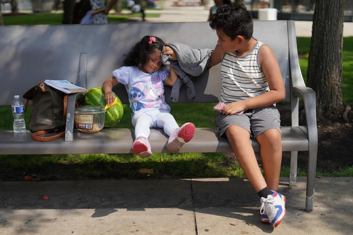 Jareht Alexander, 10, wiping sweat off his sister Leslie Juliani, 2, in Millennium Park as extreme heat and rising summer temperatures hit Chicago, Illinois, US, July 23, 2025. 