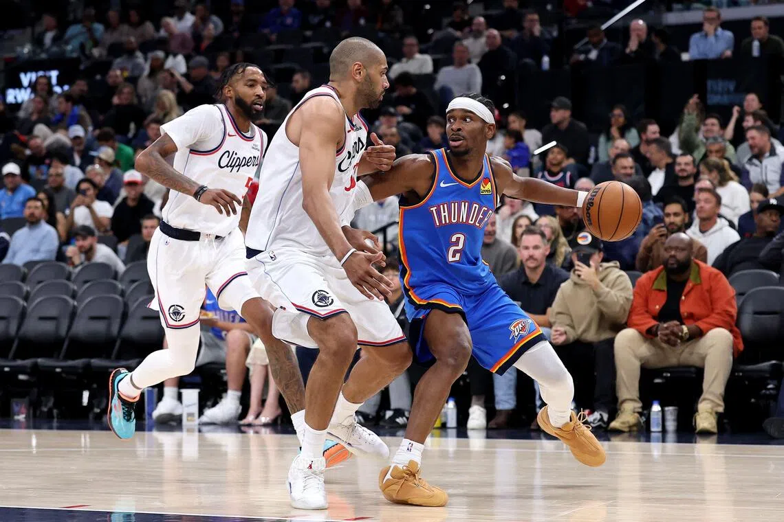 Shai Gilgeous-Alexander of the Oklahoma City Thunder dribbles the ball against Nicolas Batum (No. 33) of the Los Angeles Clippers during the third quarter at Intuit Dome.