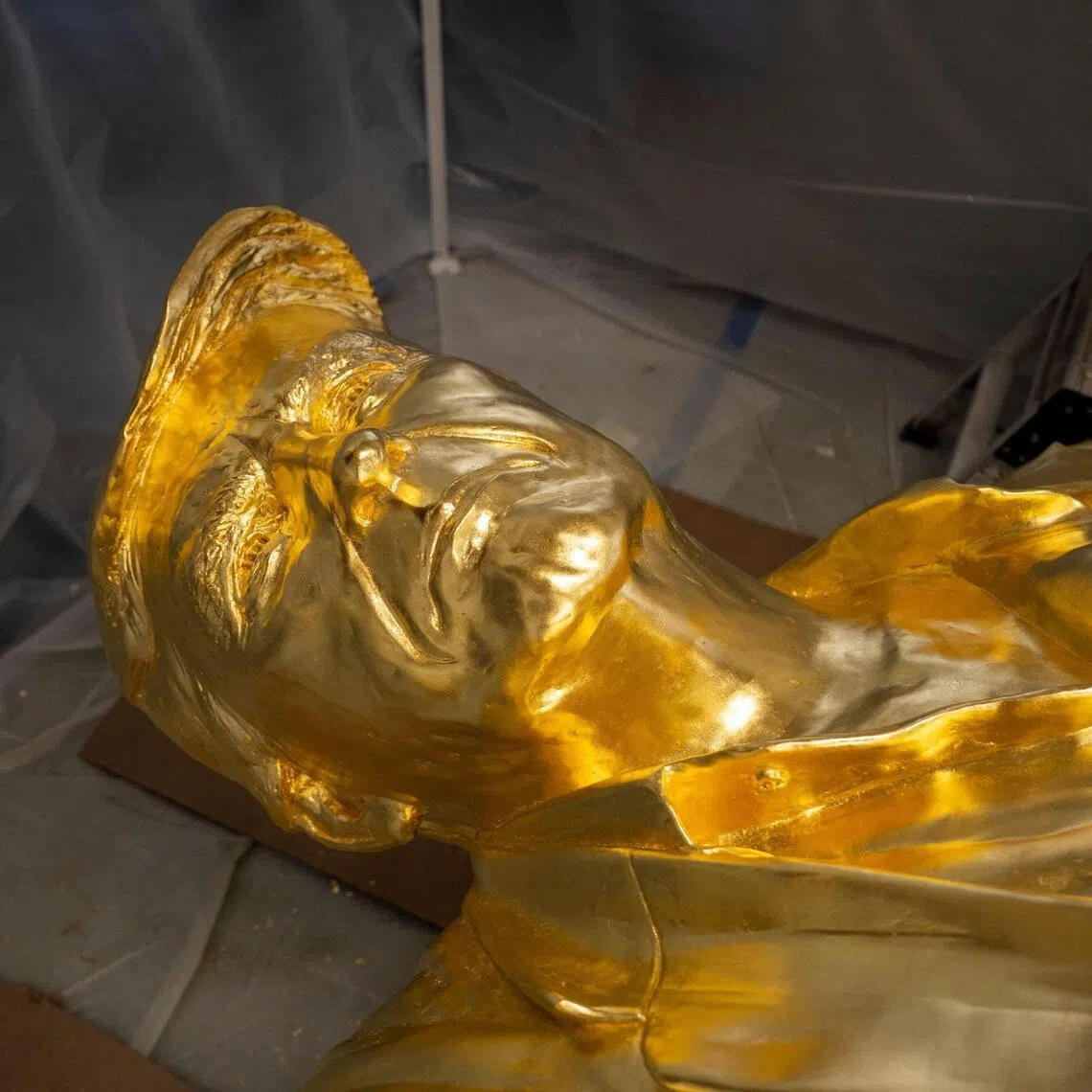 The bust portion of a 4.6mbronze statue of US President Donald Trump, coated in gold leaf, lies on its back in the studio of sculptor Alan Cottrill in Zanesville, Ohio.