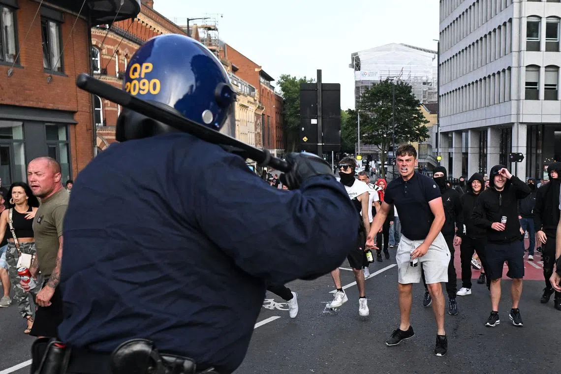 Riot police face protestors in Bristol, southern England, on Aug 3, 2024, during the 'Enough is Enough' demonstration held in reaction to the fatal stabbings in Southport on July 29. 