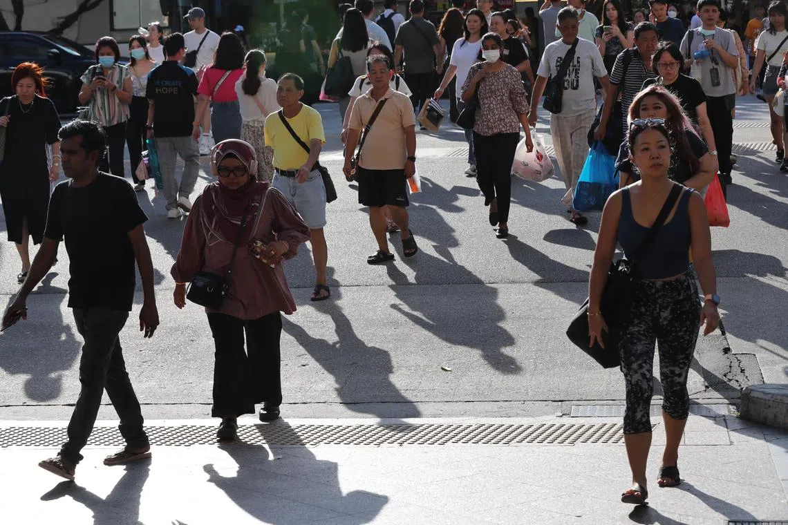 ST20230712_202362333851: Gin Tay/ pixgeneric/ Generic photo of people crossing at the traffic junction along Bugis street under the hot sun on July 12, 2023. Can use for stories on economy, GDP, population, income tax, hot weather, job opportunities, heat, climate change, 