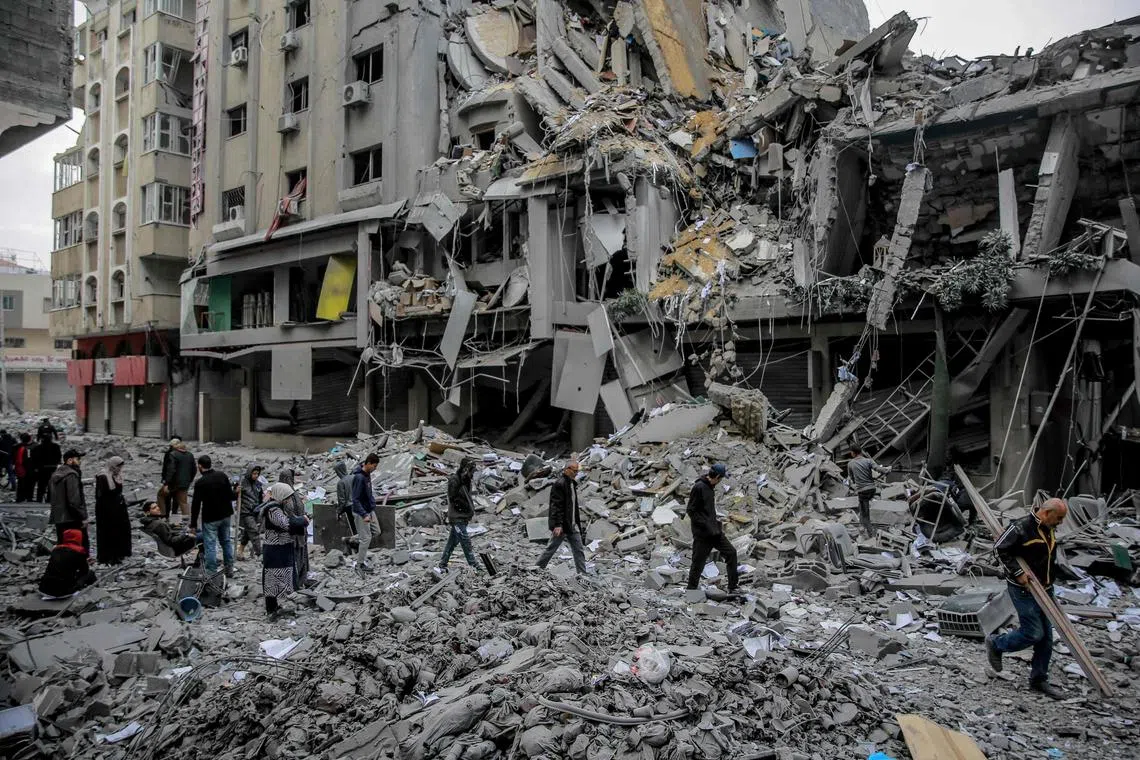 TOPSHOT - Palestinians walk amid the rubble of houses destroyed by Israeli bombardment in Gaza City on March 3, 2024, amid the ongoing conflict between Israel and the Hamas movement. (Photo by AFP)