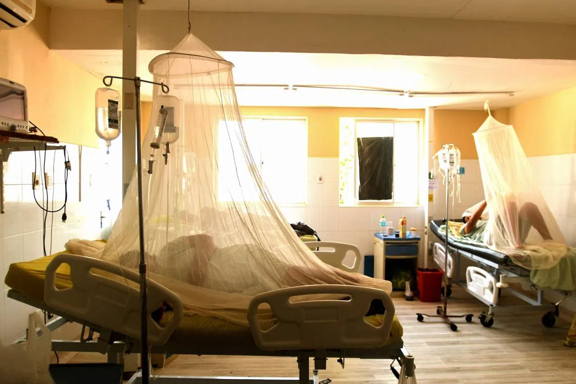Dengue fever patients rest under the mosquito nets at a hospital in Santa Cruz, Bolivia, on February 22, 2023. - Bolivia has recorded 29 deaths from dengue fever this year, with the outbreak pushing the health service in the eastern Santa Cruz region to the brink of collapse, the government said. (Photo by Rodrigo URZAGASTI / AFP)