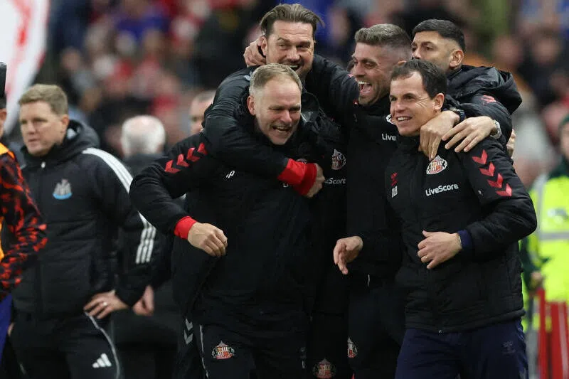 Sunderland manager Regis Le Bris and coaching staff celebrate after the match as Newcastle United manager Eddie Howe looks on.
