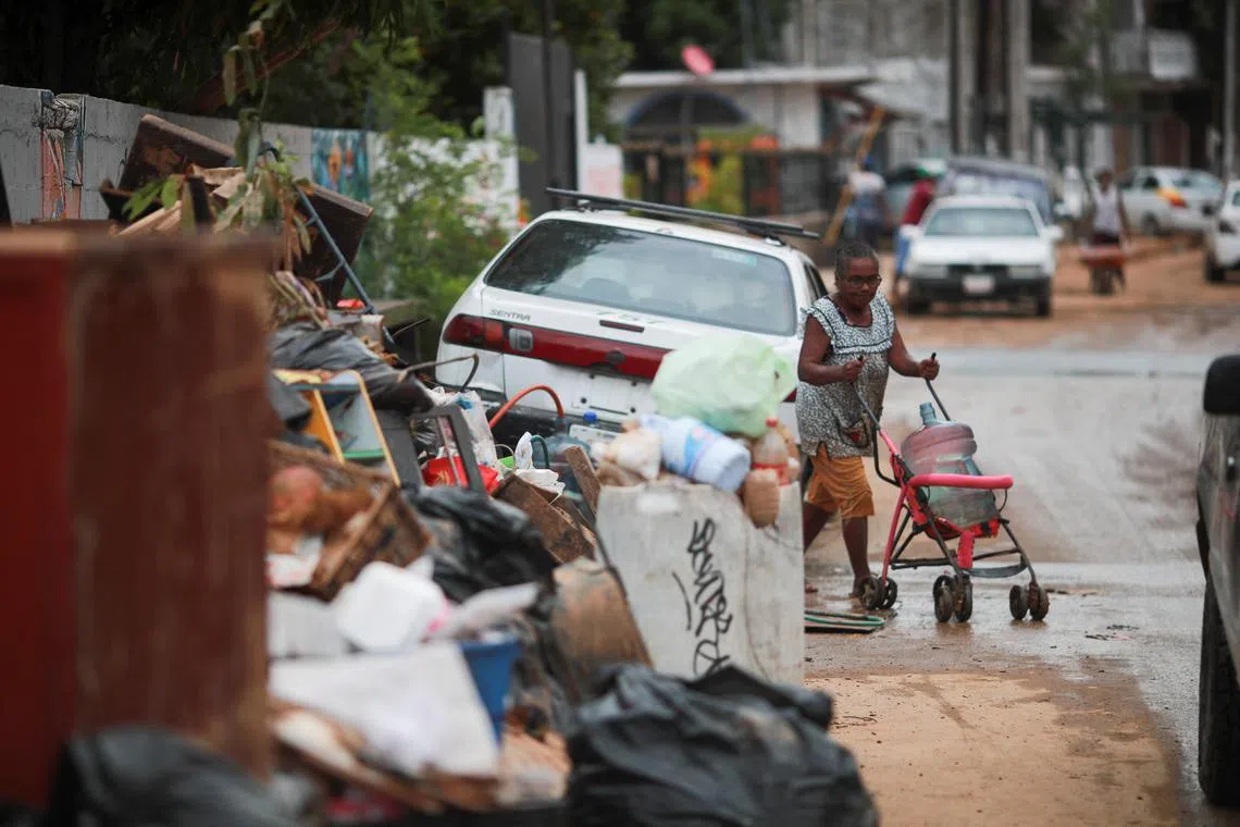 FILE PHOTO: A woman walks past debris in the aftermath of Storm John, in Acapulco, Mexico October 2, 2024. REUTERS/Henry Romero/File Photo