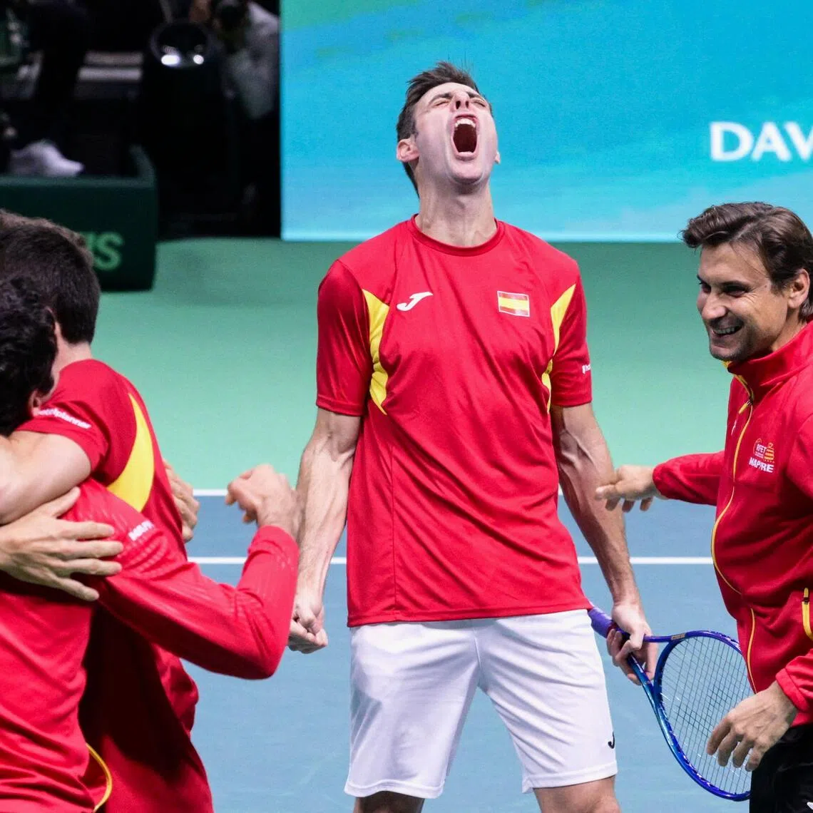 Spain's Pedro Martinez Portero (centre) celebrating Spain's victory next to teammates and captain David Ferrer (right) at the end of the 2-1 Davis Cup semi-final win over Germany at the Super Tennis Arena in Bologna on Nov 22, 2025.