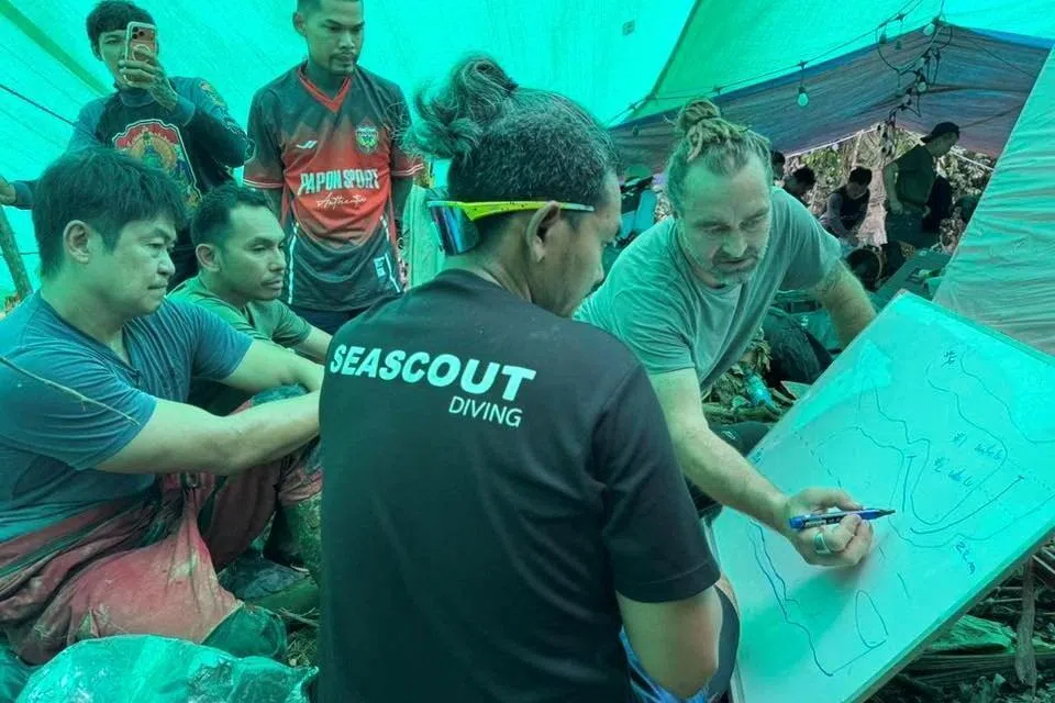 Rescue workers gather to discuss plans to rescue people trapped in a cave, in Xaisomboun Province, Laos, in this handout image released on May 29.