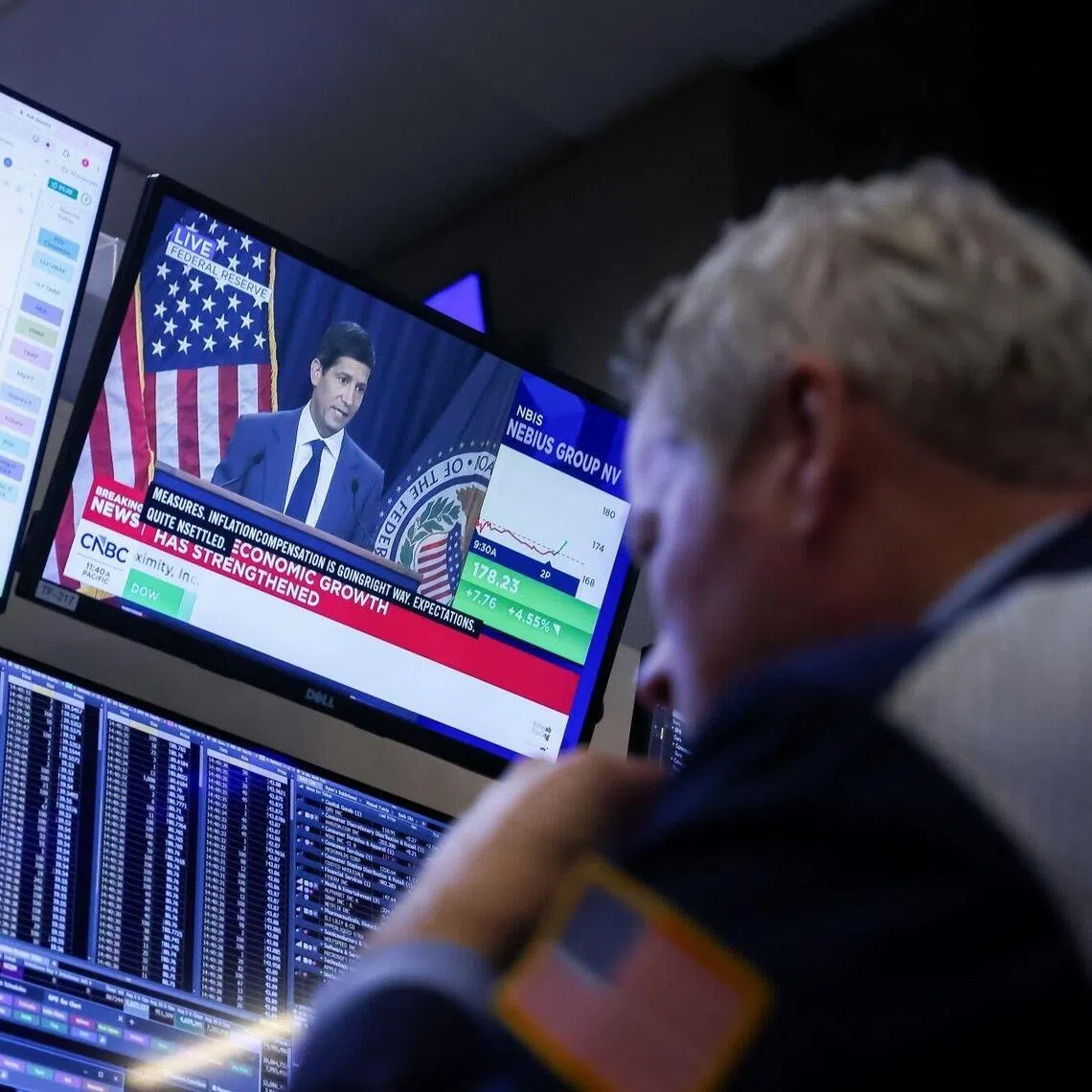 A TV station broadcasting Fed chairman Kevin Warsh on Oct 28, as traders work on the floor of the New York Stock Exchange, in New York City.