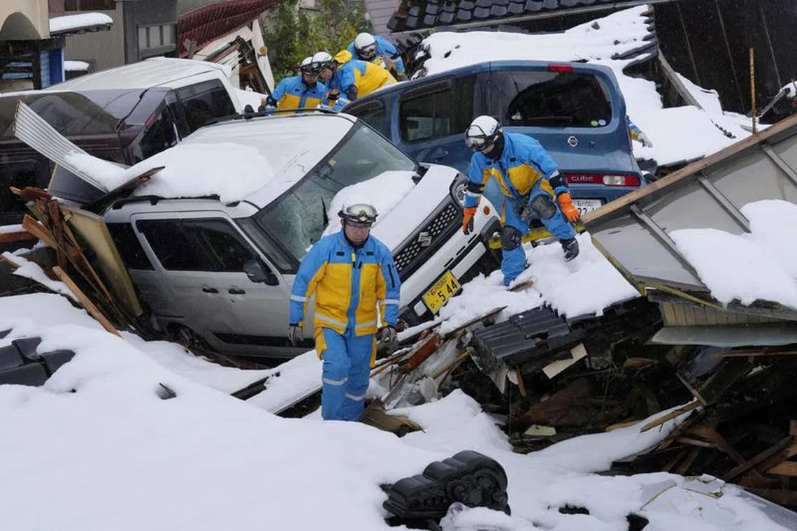FILE PHOTO: Police officers search for victims in a snow covered residential area which was devastated by a tsunami following an earthquake, in Suzu, Ishikawa Prefecture, Japan, January 9, 2024. Mandatory credit Kyodo via REUTERS/File Photo