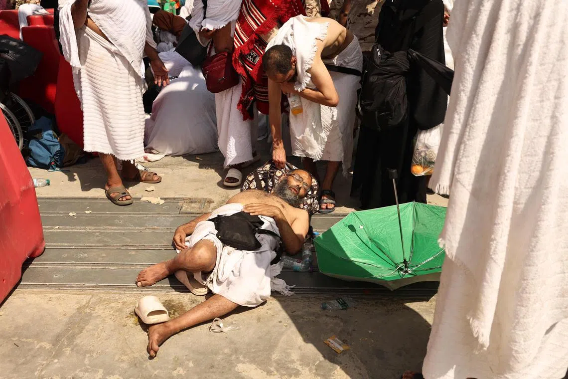 A man suffering from heatstroke is helped by another pilgrim during the annual haj pilgrimage in Mina, Saudi Arabia.