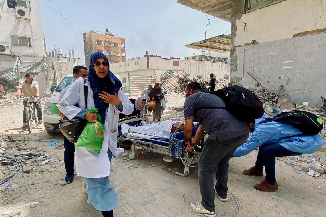 FILE PHOTO: Palestinians evacuate Kamal Adwan hospital following an Israeli strike, amid the ongoing conflict between Israel and the Palestinian Islamist group Hamas, in Beit Lahia in the northern Gaza Strip, May 21, 2024. REUTERS/Osama Abu Rabee/File Photo