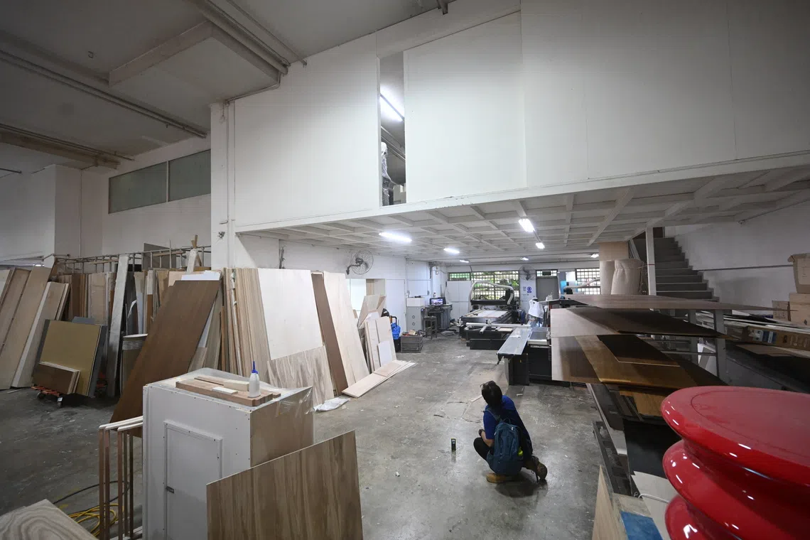 An MOM officer measuring the height of a workshop's mezzanine at a worksite in Ubi during a surprise inspection on Nov 21.