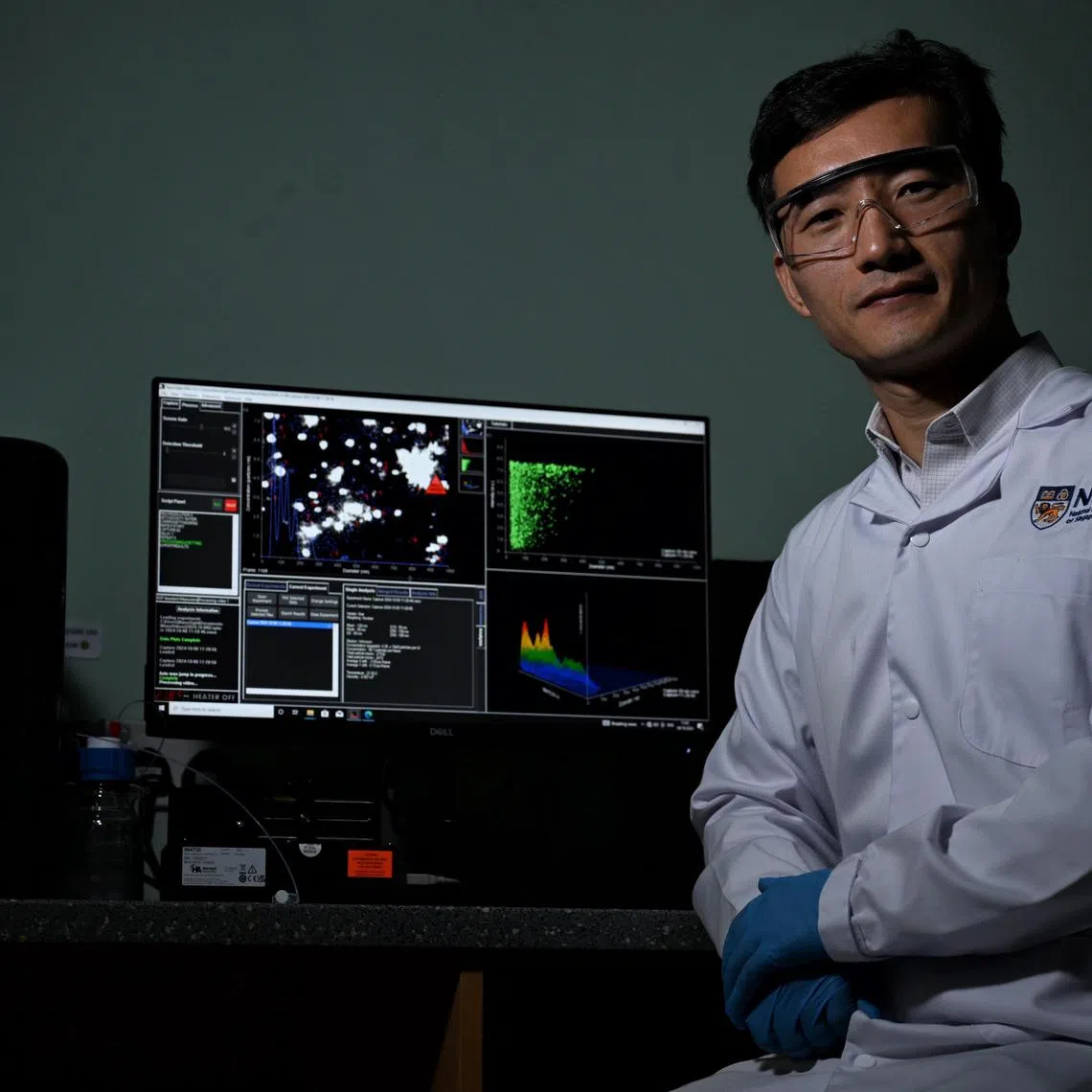 ST20241008_202454600102 aznano Chong Jun Liang
NUS assistant professor Wang Jiong-Wei using the Nanosight-NS300 in his laboratory on October 8, 2024 A team from the NUS Yong Loo Lin School of Medicine (NUS Medicine) has developed a groundbreaking technology which uses nanoparticles to diagnose and treat atherosclerosis, or the buildup of plaque in arteries. The researchers use specialised equipment, the Nanosight-NS300, to examine the size, uniformity, and concentration of the nanoparticles to assess their suitability for diagnosing and treating atherosclerotic plaque. A syringe is used to inject a sample with the synthesised nanoparticles into the equipment, and the team is able to observe the size, uniformity, and count of the synthesised nanoparticles in the sample on a screen.