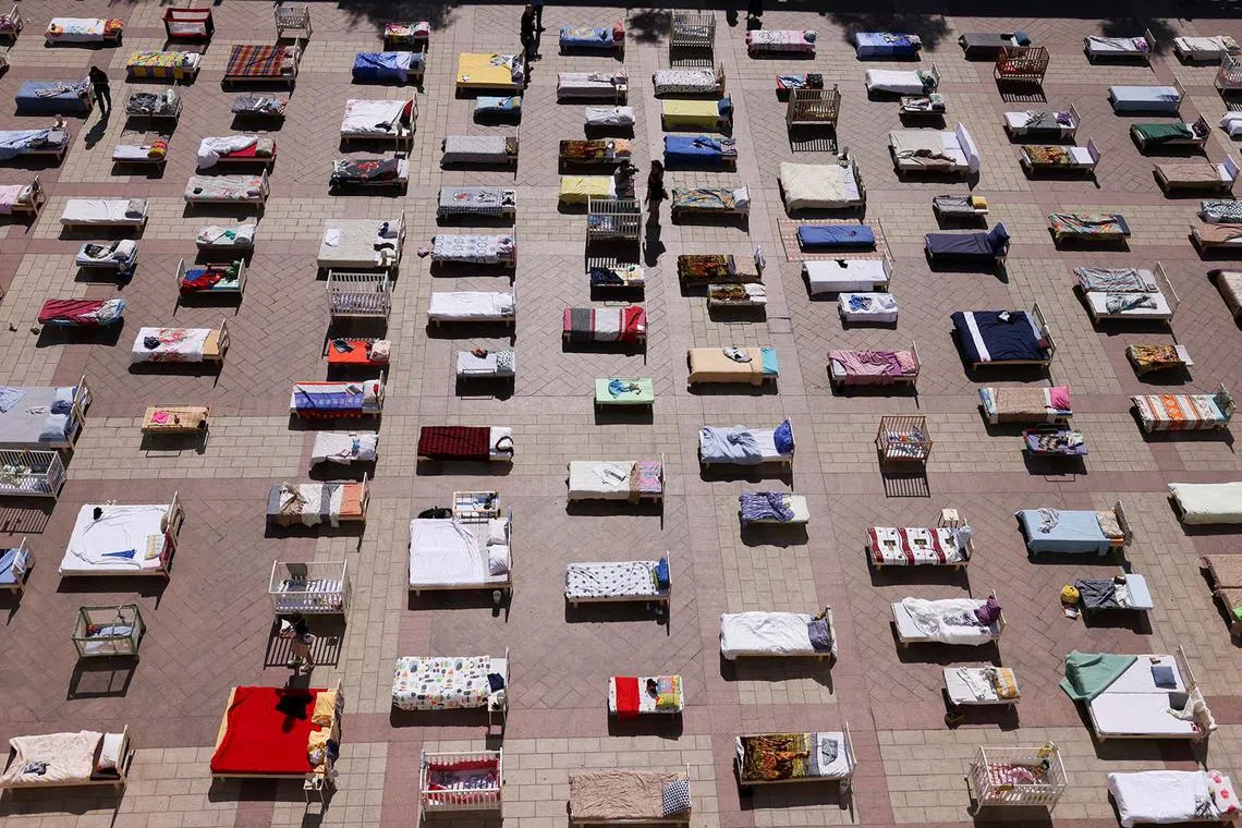People look at mattresses and beds, part of an installation "Empty Beds" initiated by survivors of Kibbutz Nir Oz and the families of hostages held in Gaza, following a deadly infiltration into southern Israel by Hamas gunmen, at a public square in Jerusalem, Oct 30.