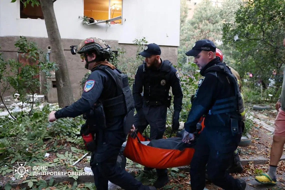 Ukrainian law enforcement officers evacuating an injured person from an apartment building damaged during a Russian missile strike on the Ukrainian city of Dnipro, on Sept 20.