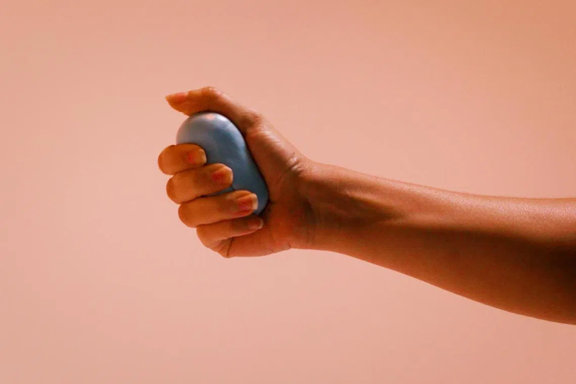 An undated photo illustrating the use of Silly Putty to exercise your tendons, ligaments and joints. 