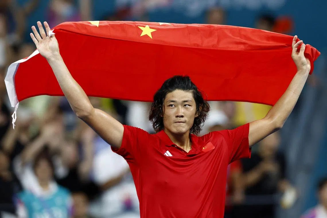 Chinese tennis star Zhang Zhizhen celebrates after beating Japan's Yosuke Watanuki to win the men's singles title at the Asian Games.
