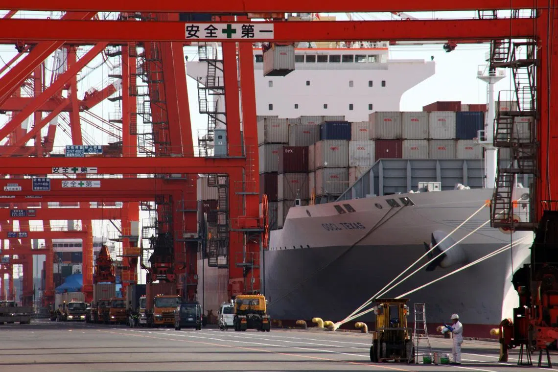 A worker is seen in front of a container ship loaded with containers at a shipping port in Tokyo, Japan, on Wednesday, Jan. 27, 2010. Japan's exports rose for the first time since Lehman Brothers Holdings Inc. collapsed 15 months ago, adding to signs that the world's second-largest economy is recovering from the global recession. Photographer: Tomohiro Ohsumi/Bloomberg