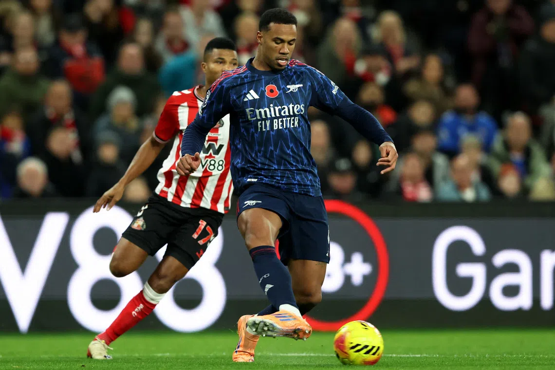 Soccer Football - Premier League - Sunderland v Arsenal - Stadium of Light, Sunderland, Britain - November 8, 2025 Arsenal's Gabriel Magalhaes in action with Sunderland's Reinildo Mandava REUTERS/Scott Heppell
