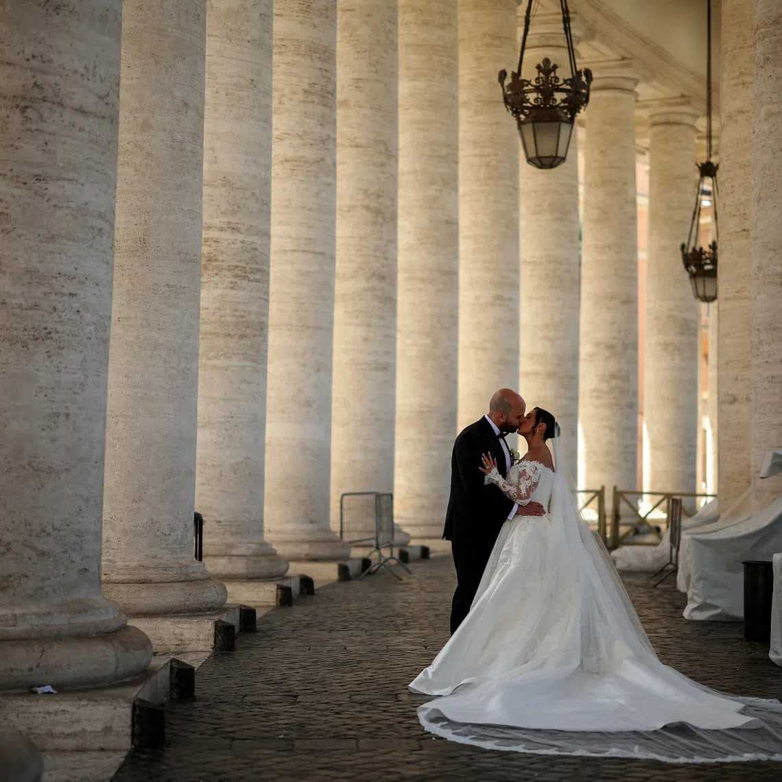 FILE PHOTO: A couple kiss during their wedding photo session under the Vatican colonnade in the Vatican, April 29, 2025. REUTERS/Stoyan Nenov/File Photo