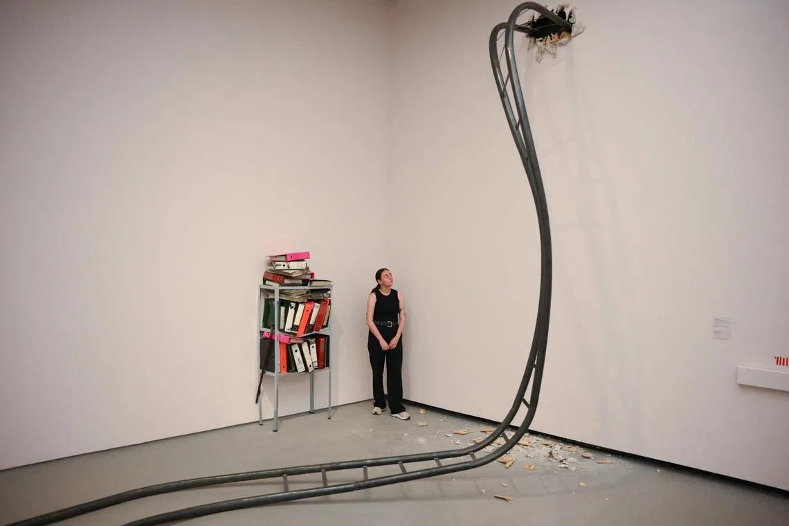 A gallery assistant posing next to installations by artist Jesse Darling entitled 'Big Dipper' and "Epistemologies" during a media tour for the Turner Prize 2023 at the Towner Eastbourne gallery in Eastbourne, southern England, on Sept 27.