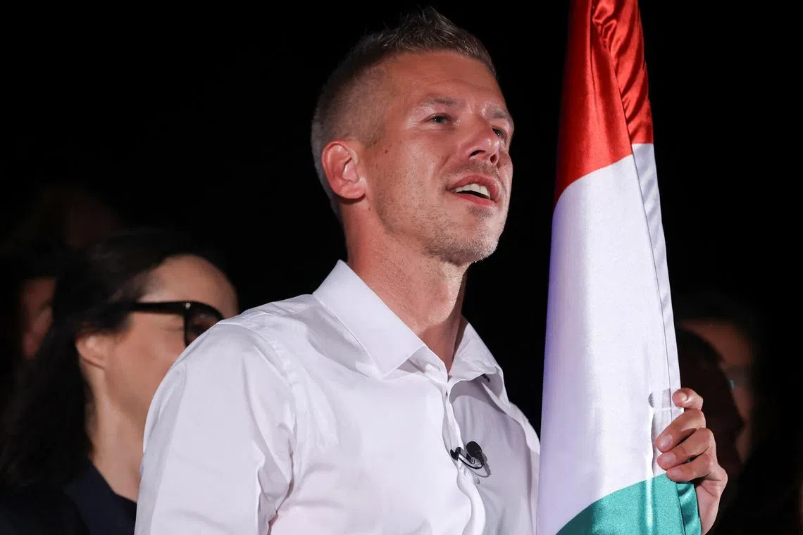 FILE PHOTO: Peter Magyar, former government insider and leader of the Respect and Freedom (TISZA) Party, holds a Hungary flag as he speaks after the announcement of the partial results of the European Parliament and municipal elections, in Budapest, Hungary, June 10, 2024. REUTERS/Bernadett Szabo