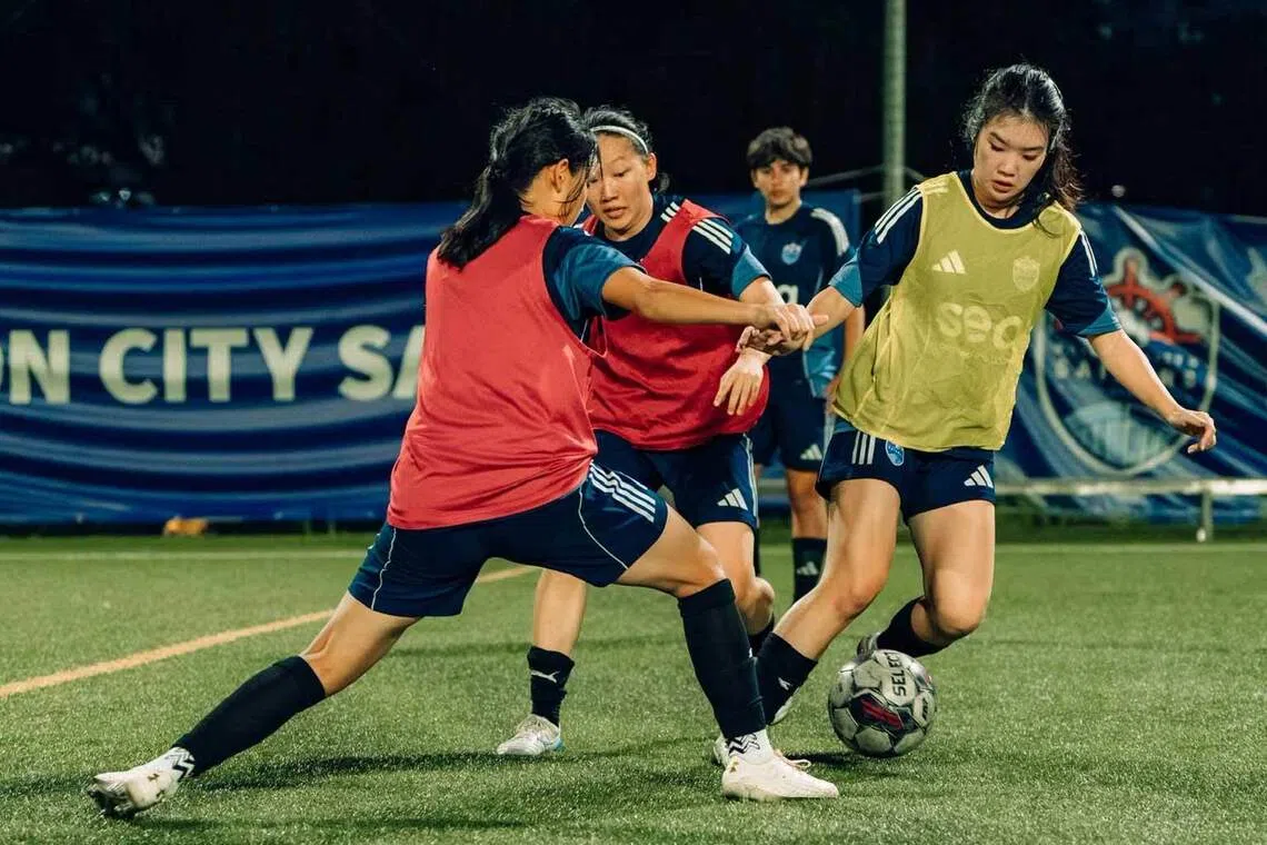 girls from the lion city sailors girls academy contest the ball during football training