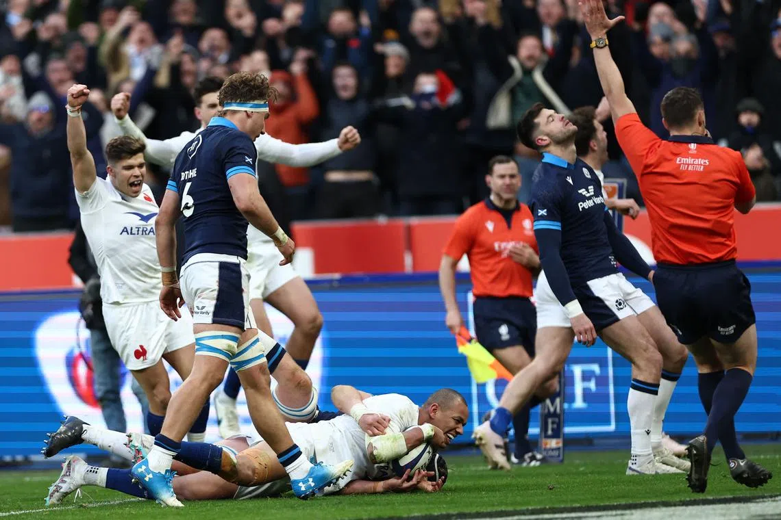 France's centre Gael Fickou (bottom) scores a try at the Stade de France in Saint-Denis, northern Paris, on Feb 26, 2023.