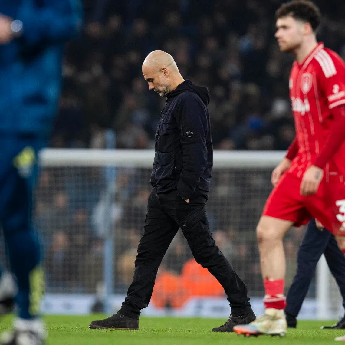 Manchester City manager Pep Guardiola walk on the pitch after the 2-2 Premier League draw with Nottingham Forest.