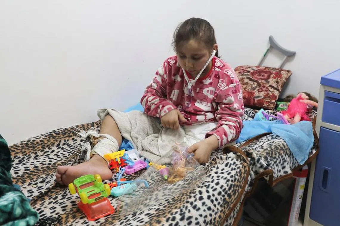 FILE PHOTO: Palestinian girl Noor Marouf, whose limb was amputated after being wounded in an Israeli strike, sits on a bed as she receives treatment at the European Hospital, in Rafah in the southern Gaza Strip, December 28, 2023. REUTERS/Arafat Barbakh/File Photo