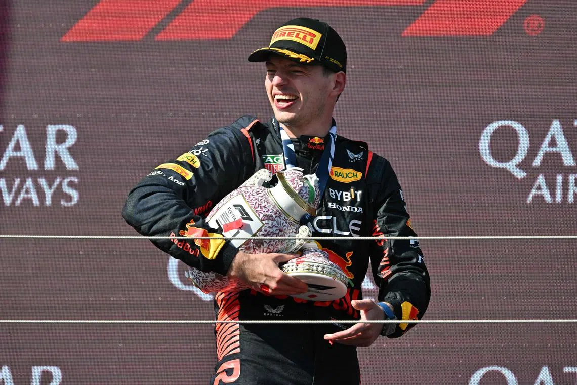 Hungarin gran prix winner Max Verstappen leaves the podium with his broken trophy.