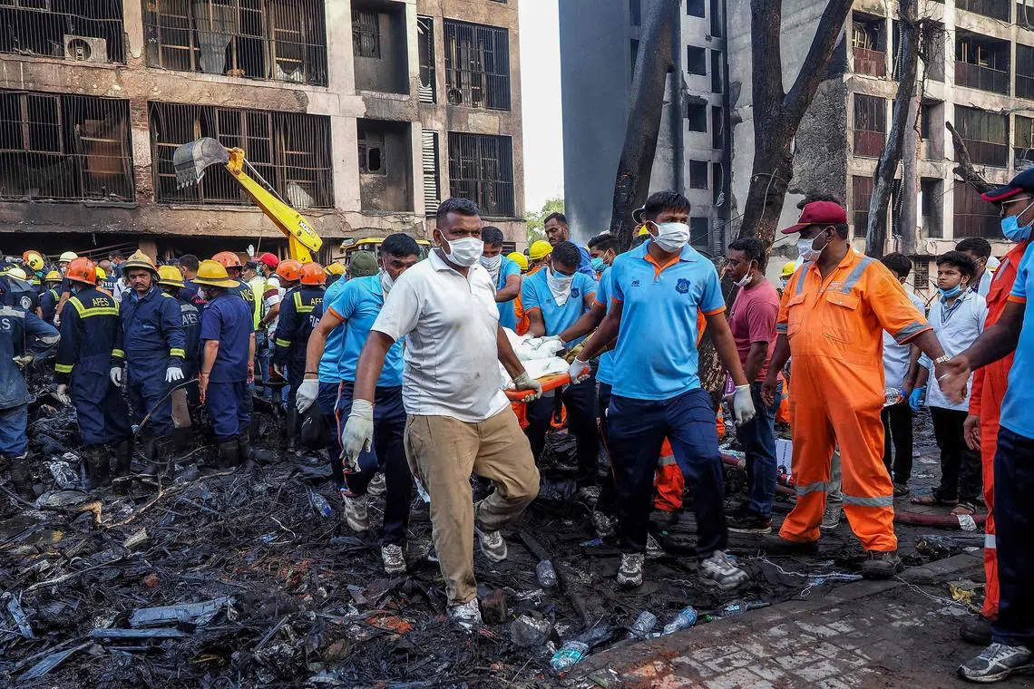 Rescue officials carrying a victim's body at the crash site in the Indian city of Ahmedabad on June 12.
