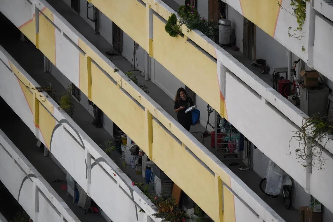 ST20201005_202054530522 Kua Chee Siong/ pixcovid06/Generic pix of a woman pulls down her mask as she walks along a corridor at the HDB block along Upper Cross Street on 5 Oct 2020.Covid-19 related generics including crowds of people in masks, QR code scanning, people shopping, general retail, people wearing masks, temperature taking, public transport, foreigners for E-Pass stories.