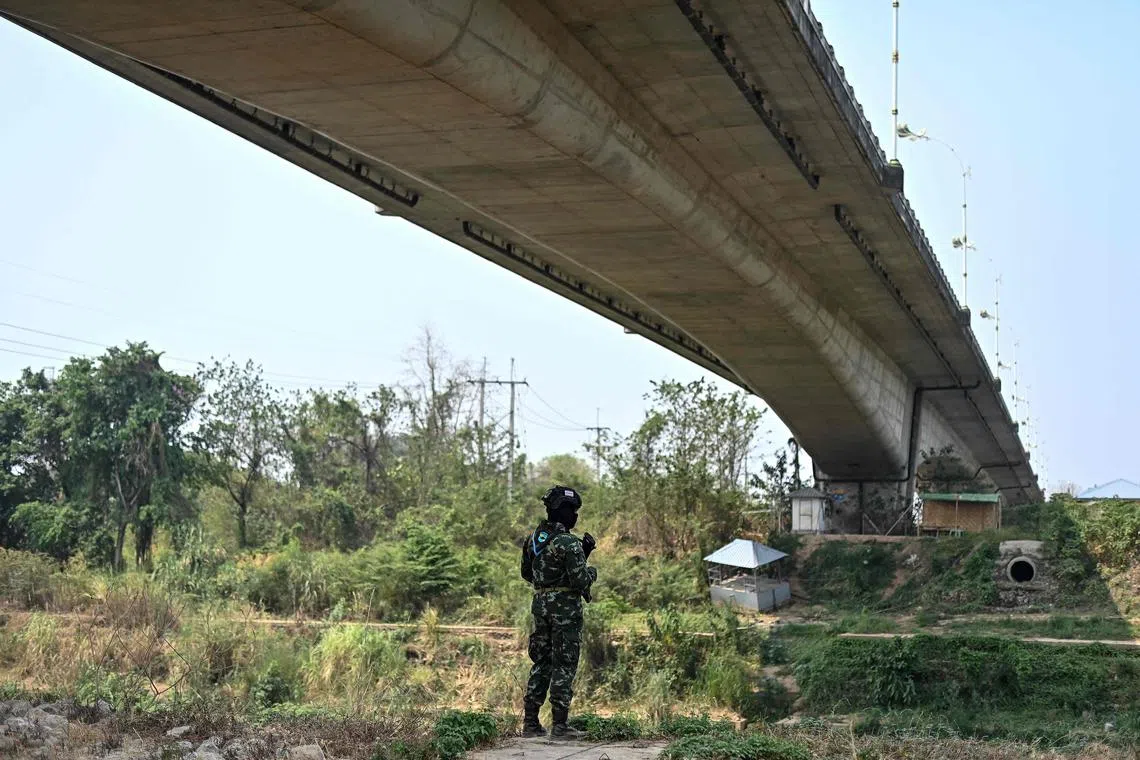 Thai military personnel keeps guard along the Moei river on the Thai side, under the 2nd Thai-Myanmar Friendship Bridge in Thailand’s Mae Sot district on April 11, 2024. Myanmar junta troops have withdrawn from a major trade hub near the Thai border following days of clashes, an ethnic armed group told AFP on April 11, 2024, dealing a further blow to the embattled military. (Photo by MANAN VATSYAYANA / AFP)